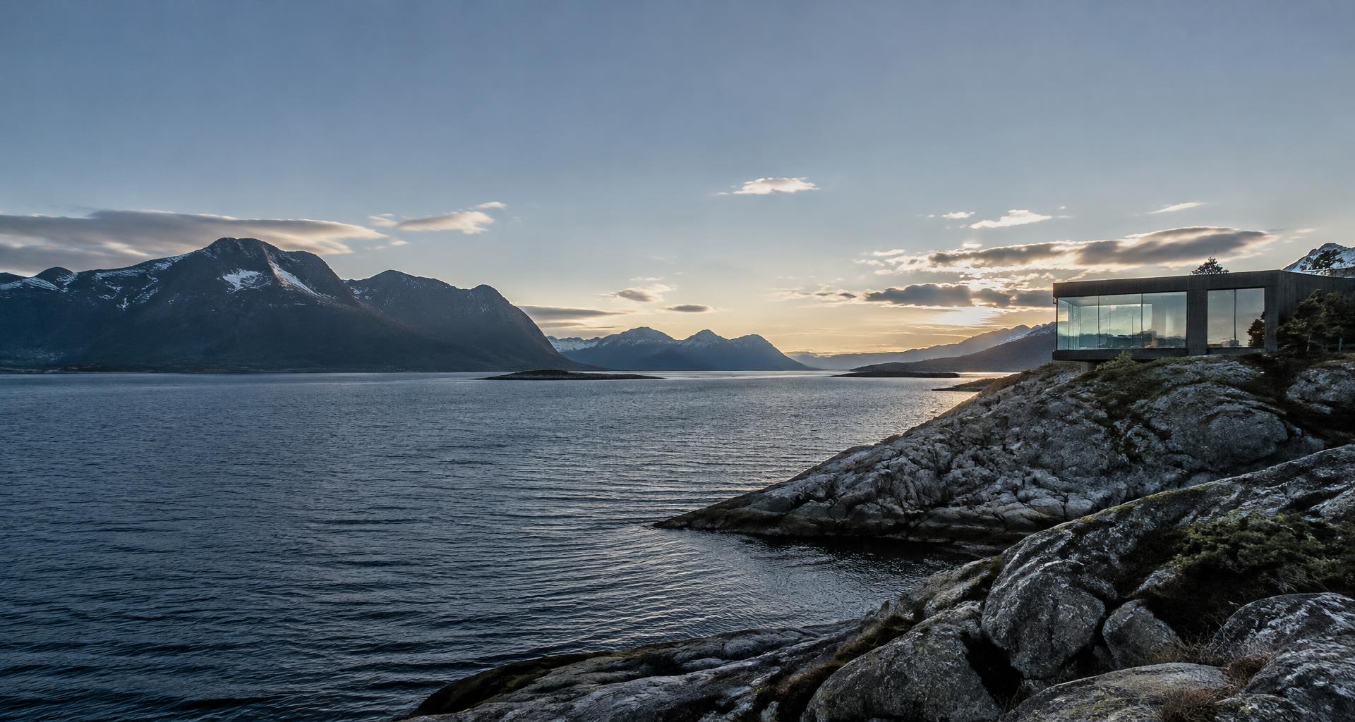 Illustrasjon av et moderne bygg ved en norsk fjord og fjell
